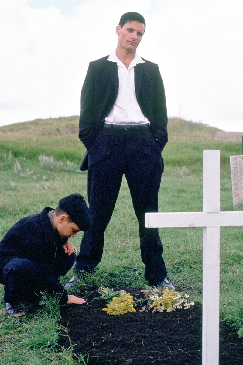 man and boy at fresh grave