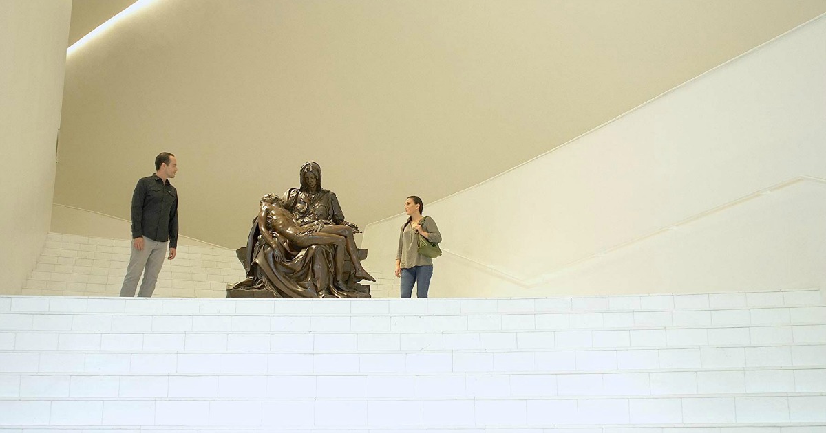 man and woman viewing statue