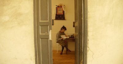looking through a doorway at a woman reading a book