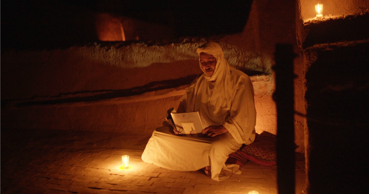 man reading by candlelight