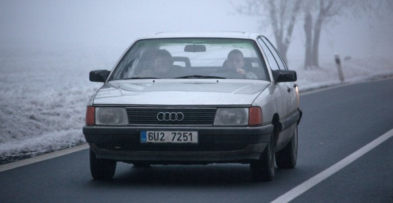 car driving on a road surrounded by snow