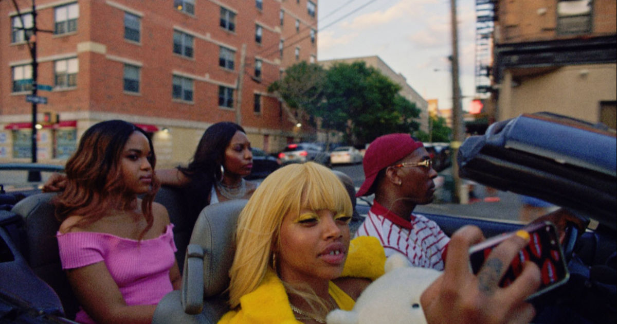 people driving through city in convertible