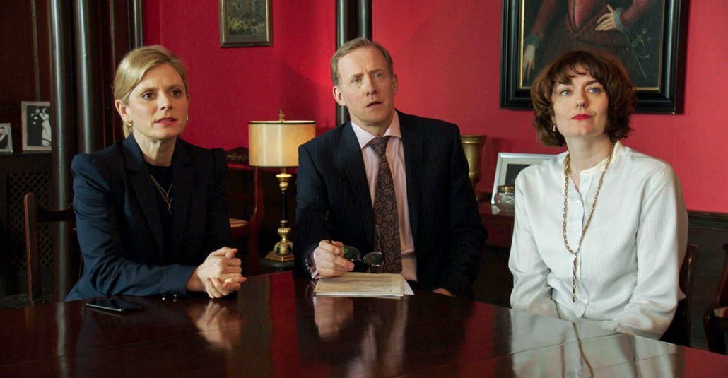 man and two women at conference table