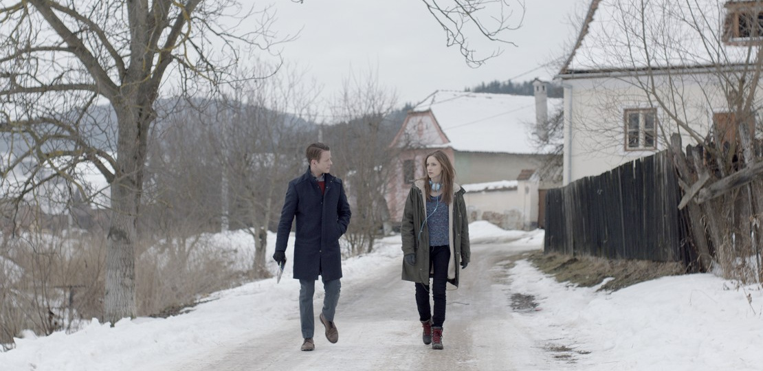 man and woman walking on snowy road