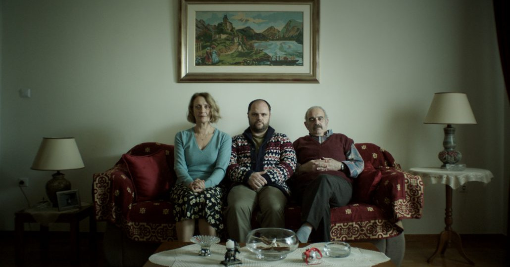 three adults sitting on sofa