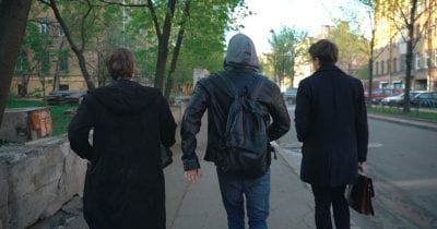 three russian comrades walking on sidewalk