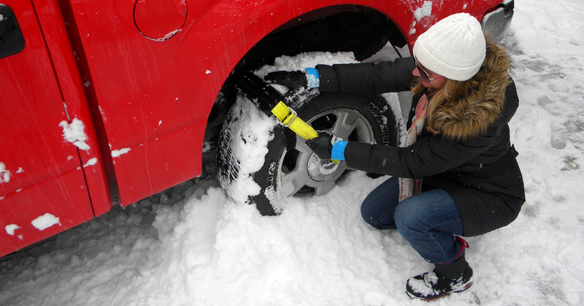 woman putting trac grabber on red truck