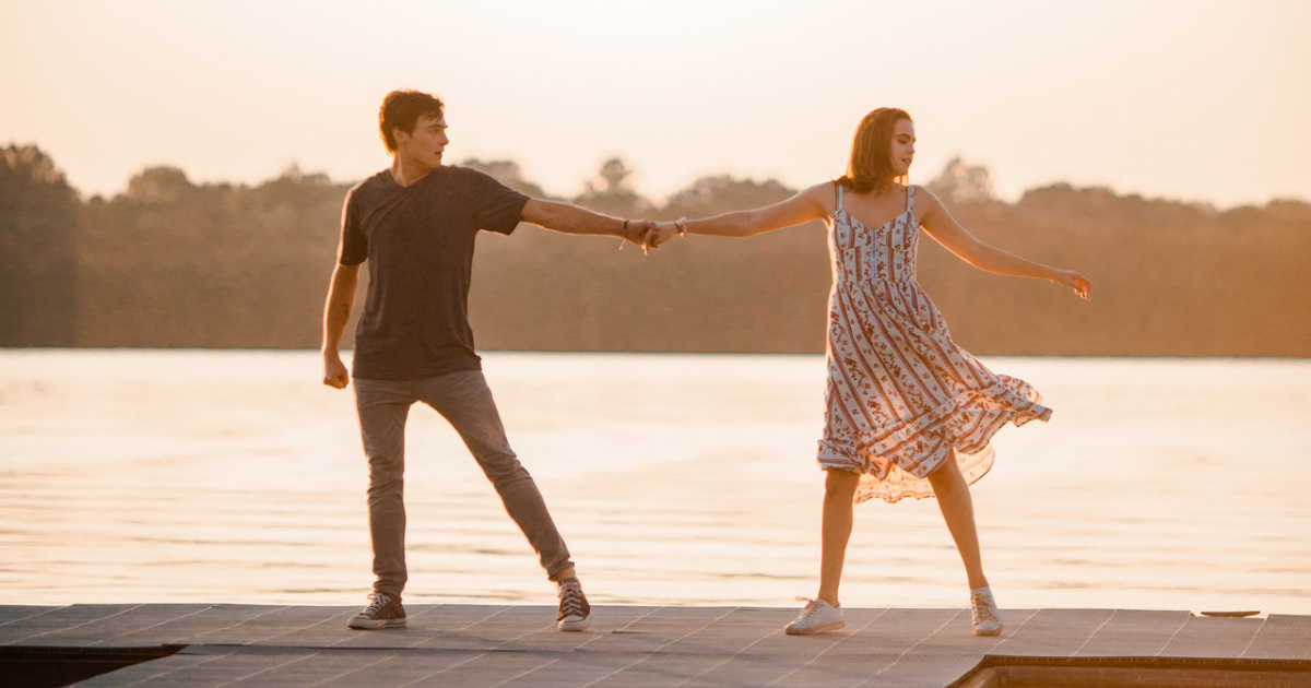 teens dancing on dock by lake.