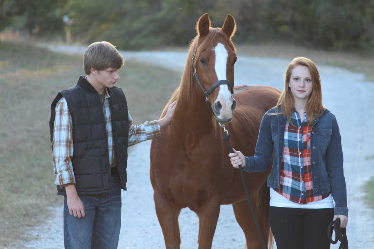 two teenagers with horse