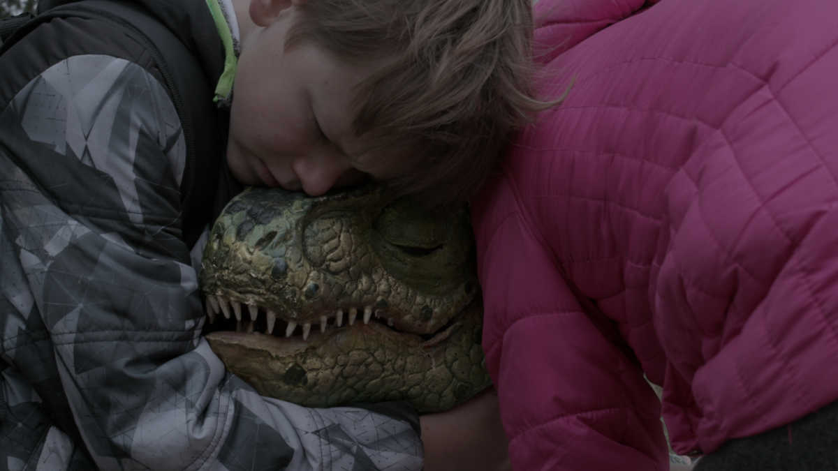 boy hugging dinosaur