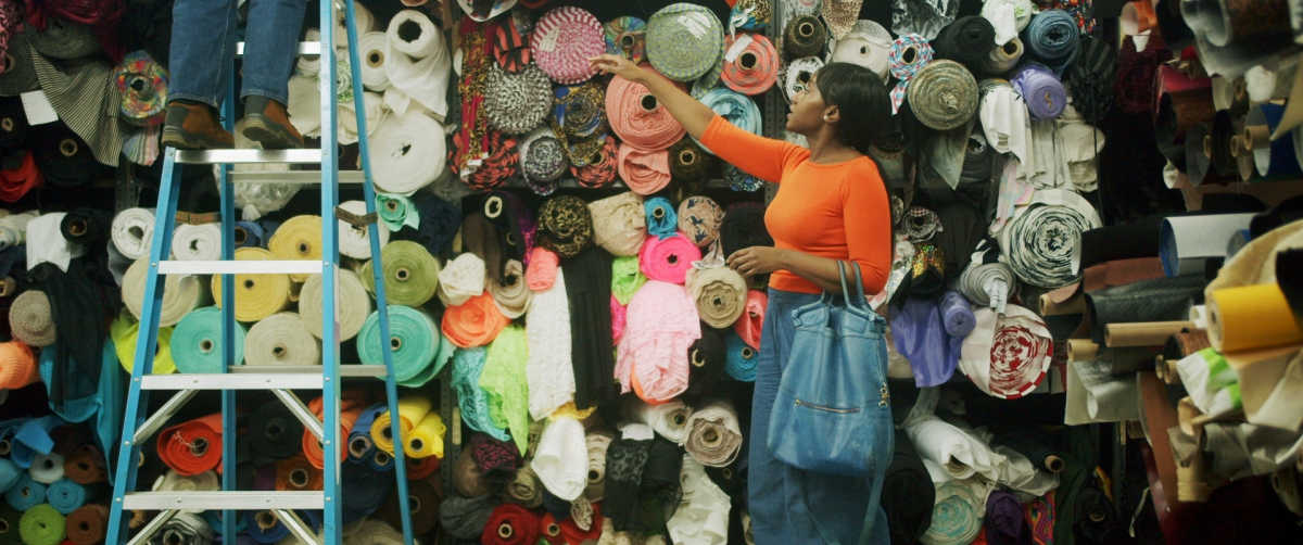 woman shopping for bolts of fabric QOG