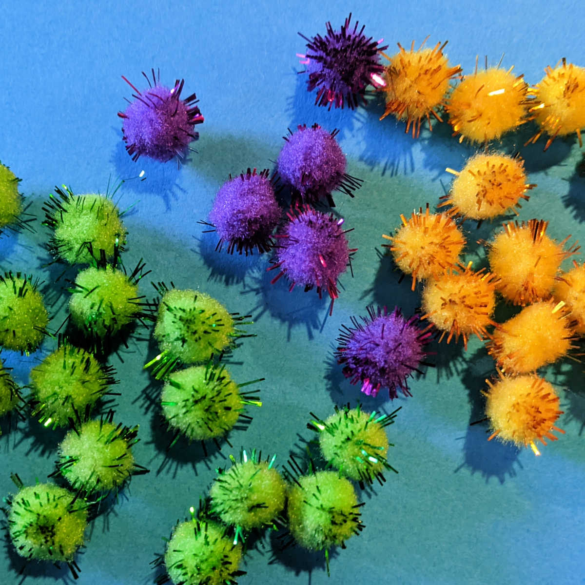green purple and gold pom poms