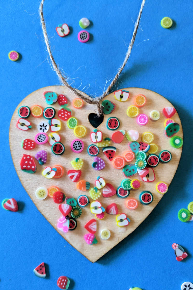 Make an easy fruit lovers heart craft with unfinished wood and little polymer fruit slice confetti in vibrant colors.