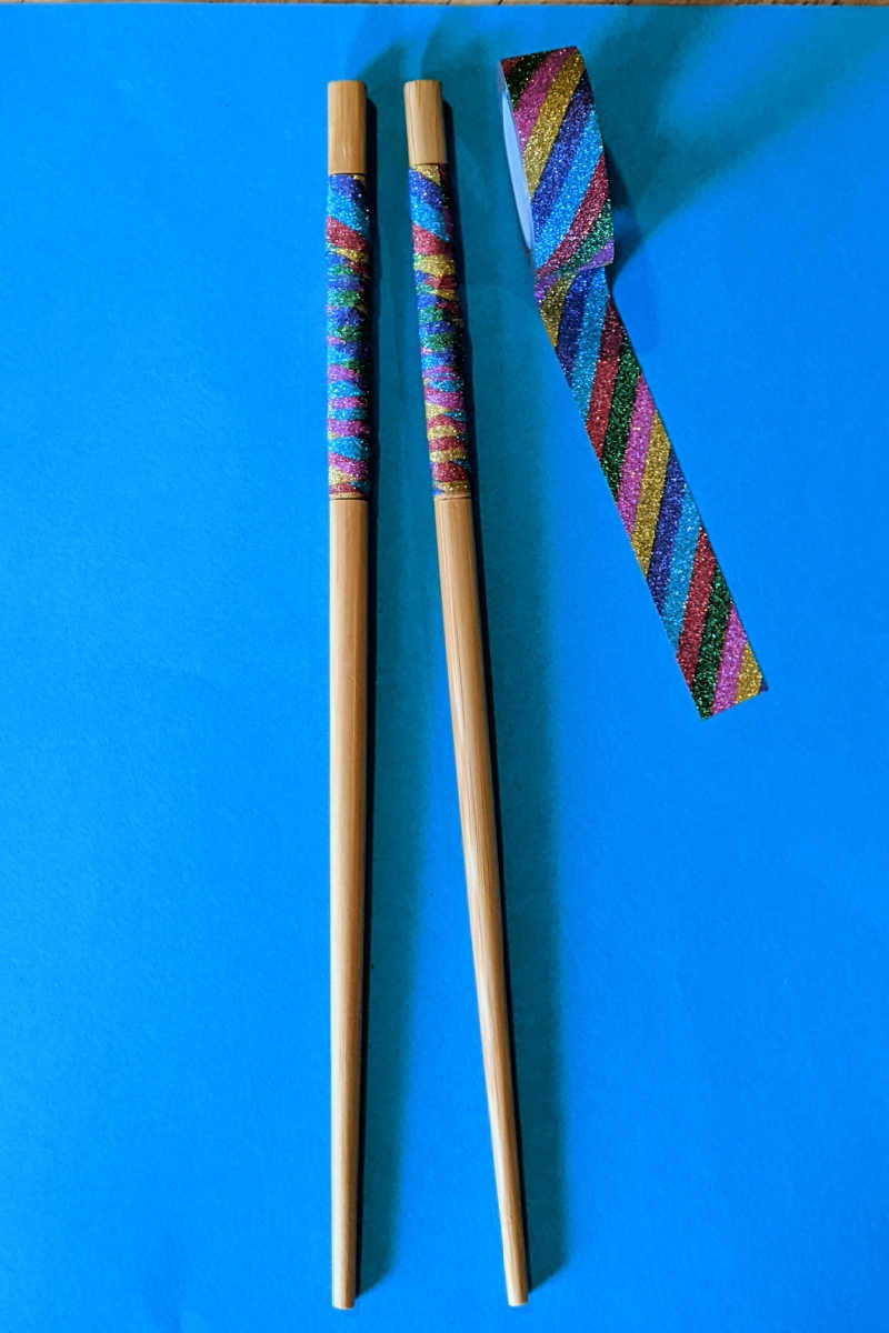 Looking for a fun and easy craft to do with your kids? Look no further than this rainbow washi tape chopsticks craft!