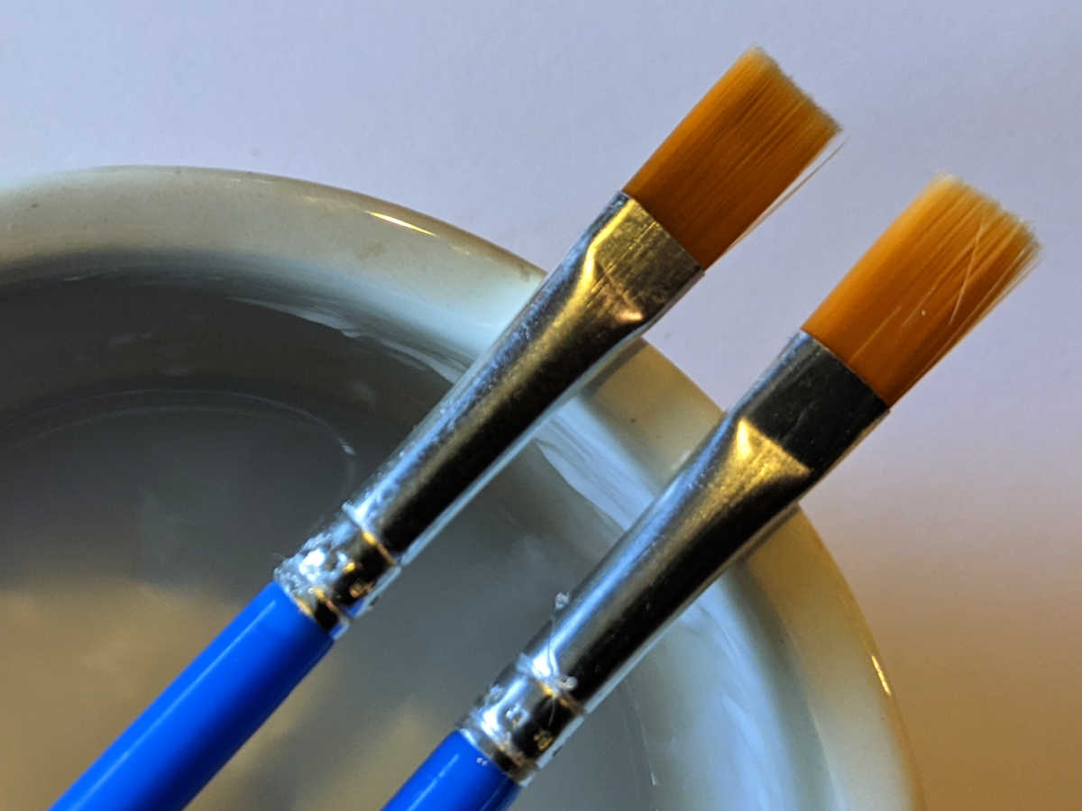 paint brushes and bowl of glue