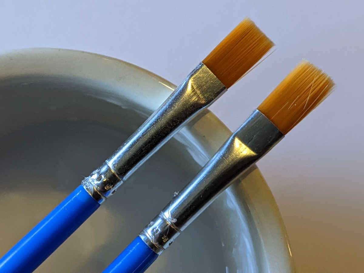 paint brushes with bowl of glue