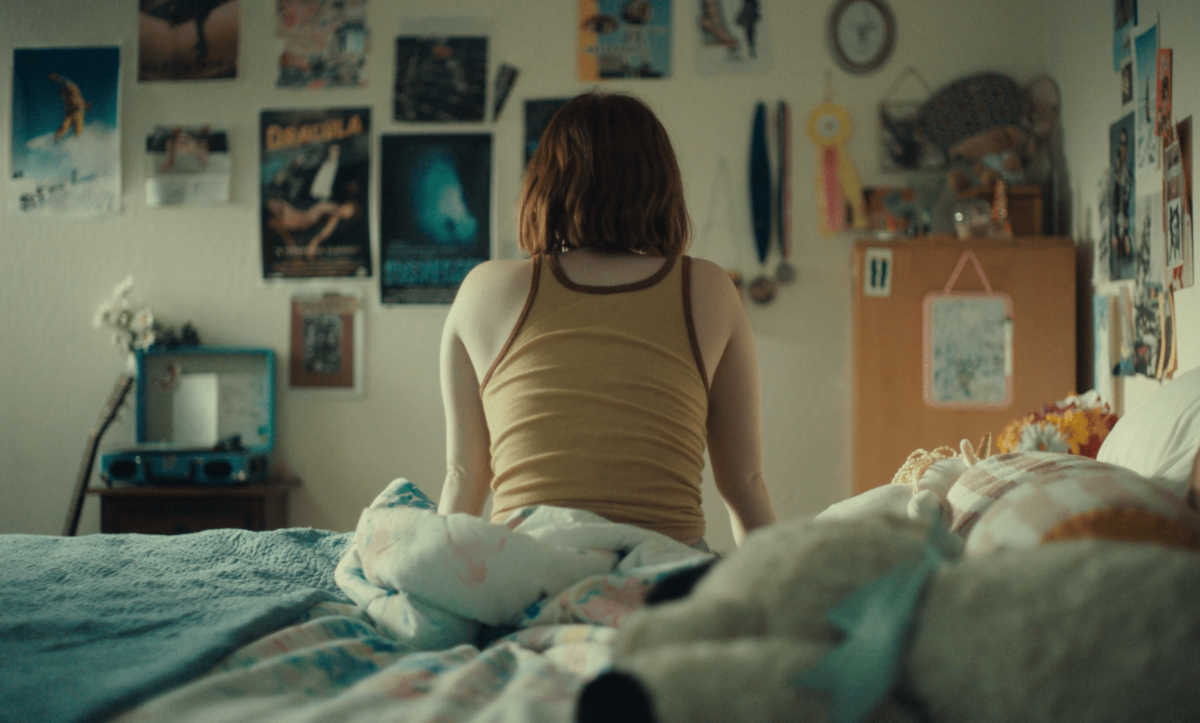teen sitting on edge of bed
