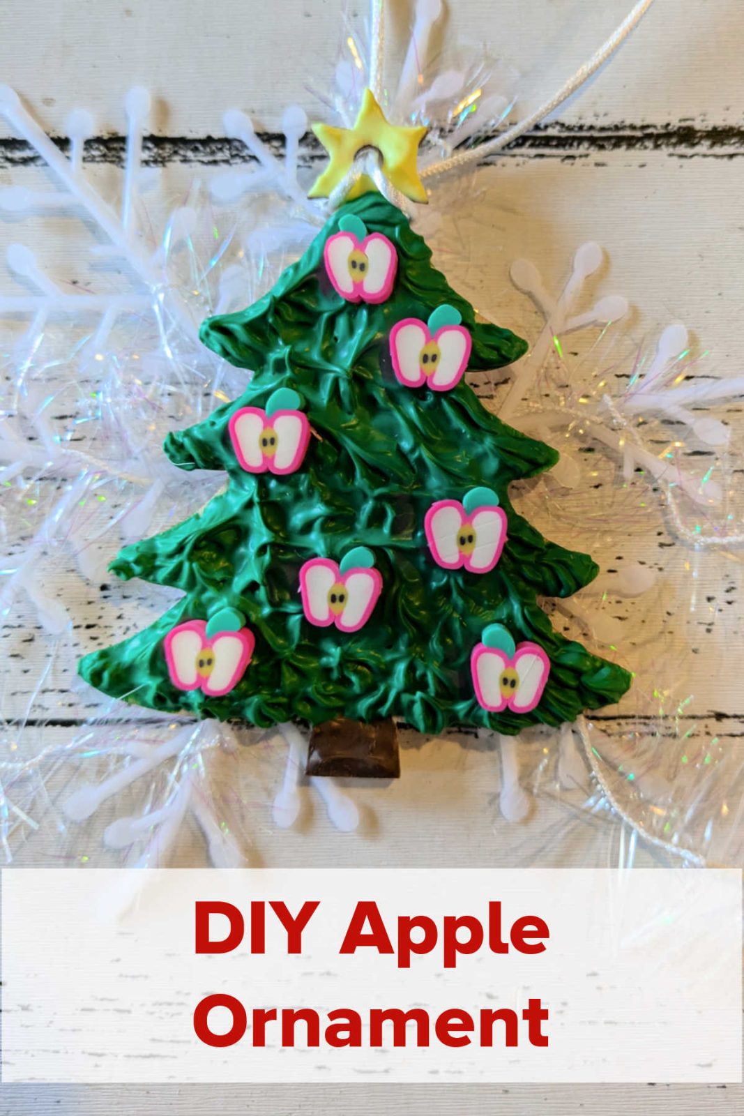 Add a touch of autumn charm to your holiday decor with this DIY Apple Christmas Ornament! The easy craft uses cream glue, apple decorations, and your creativity to create a unique and festive ornament. This is a perfect little gift for teachers, friends, and family.