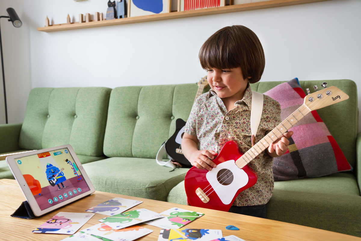 kid learning how to play loog guitar