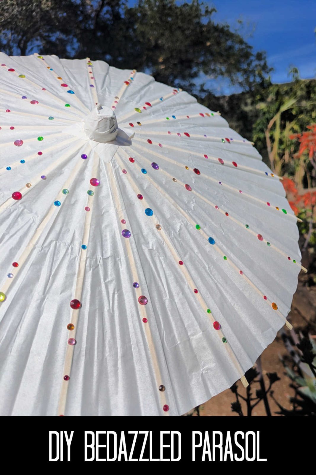 Looking for a simple and sparkling activity? This DIY bedazzled parasol craft is perfect for toddlers and big kids alike using paper umbrellas and gem stickers!
